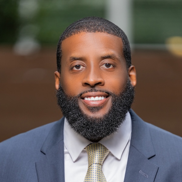 Dr. Toron Wooldridge dressed in a suit and tie smiling to camera 